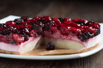Mousse cake with berries on wooden background