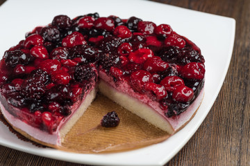 Mousse cake with berries on wooden background