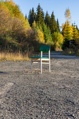 Single white wooden chair outdoors on gravel