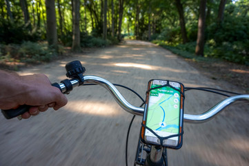 Cycling by map and phone through park while traveling and exploring