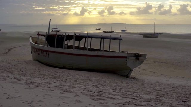 Pan Up on Fishing Boat on Sea Sand Overlooking Ocean at Sunset in Vilankulos, Mozambique