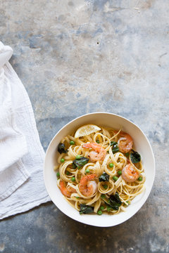Bowl of shrimp pasta on gray surface