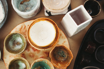 Ceramic tableware and cutlery on wooden background. Сoncept pottery of different colors. Top view, flatlay, сopy space for text.