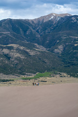 Group walking along sand dune in mountains - 228756999