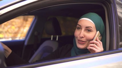 Portrait muslim businesswoman in hijab in the car and talking on the phone