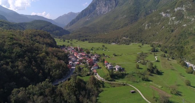 Aerial background drone view of a small alpine town, near soca river, on a sunny summer day, in the Julian alps, Slovenia