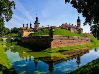 Fototapeta premium View of Nezvish Palace on a beautiful sunny day of a summer in the Minsk region, in Belarus - Different styles, the fortification is an UNESCO heritage site, also known as Niasvižski zamak.