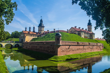 View of Nezvish Palace on a beautiful sunny day of a summer in the Minsk region, in Belarus - Different styles, the fortification is an UNESCO heritage site, also known as Niasvižski zamak.
