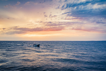 Fishing boat in the blue sea at dusk with blue sky in the city of São José do Ribamar, Maranhão state, Brazil