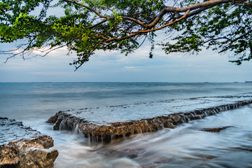 Sea waves of blue water passing over rocks on the beach of São Marcos, São Luis city, Maranhão state, Brazil