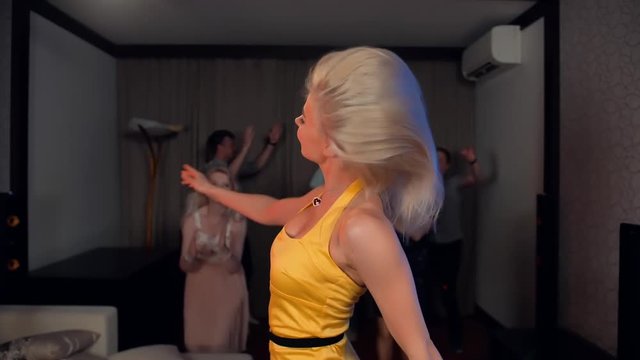 Beautiful sexy awesome attractive young blondie lady dancing in yellow bright dress. Sexy party dancing super slow motion shot. Smiling and happiness alcohol home party.