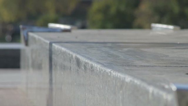 Skateboarder try a grind trick on ledge and skate truck stops slide, slowmotion