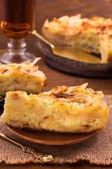A piece of sweet pastry pie with a curd layer on a round plate.