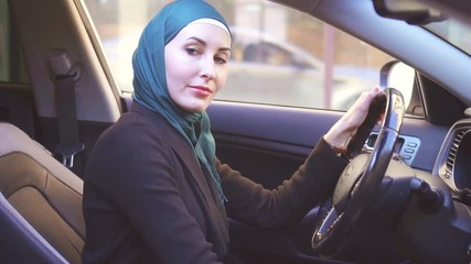 Portrait muslim woman in hijab in car,slow mo