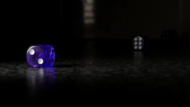 A set of blue dice being thrown