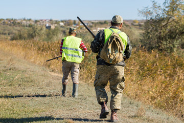 Hunters with a german drathaar and spaniel, pigeon hunting with dogs in reflective vests