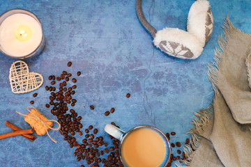 Flat lay with candle, scarf, mug of cocoa, coffee or hot chocolate with scattered coffee beans