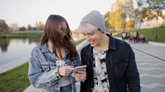 Young couple using smart phone while walking in the city