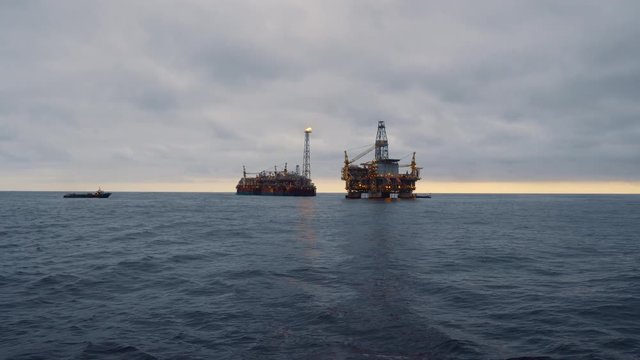 FPSO tanker vessel near Oil Rig platform. Offshore oil and gas industry. Flare is burning with smoke. Environmental pollution