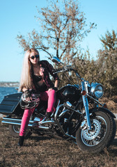 Plakat Beautiful woman posing on motorcycle outdoor. 