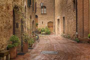 Flowery streets on a rainy spring day in a small magical village Pienza, Tusc