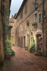 Flowery streets on a rainy spring day in a small magical village Pienza, Tuscany