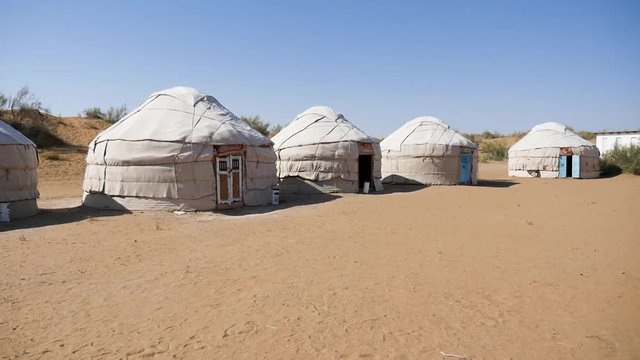Yurt camp in the desert. Panning shot of a series of yurts. Filmed in Uzbekistan. Setting similar to Mongolia or other stan countries