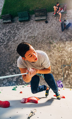 Young climber descending on rope of artificial wall