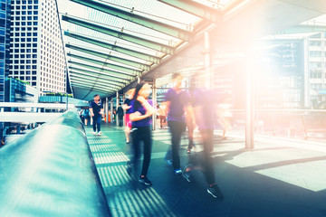 people on foot bridge against sun ray while after work 