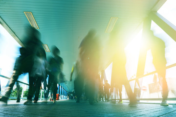 people on foot bridge against sun ray while after work 