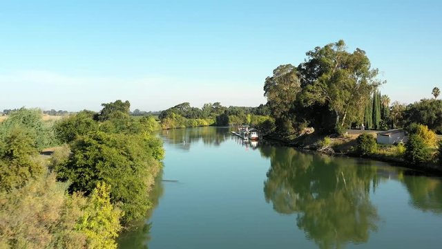 Low Flying Aerial Over Calm River Waters In Sacramento San Joaquin River Delta Ending In Reveal Of Grand Island Mansion In Walnut Grove