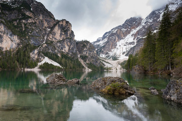 Fototapeta na wymiar Magnificent lake Lago di Braies. The emerald smooth surface of water reflects the wood and mountains around. Walk to South Tyrol, Italy. The concept of walking and eco-tourism