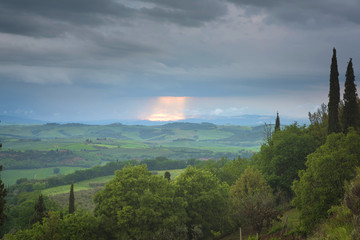 Tuscany cloudy landscape. Typical for the region tuscan farm house, hills, vineyard. Italy