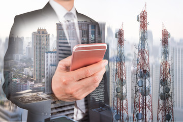 Double exposure of businessman use smartphone, communication tower or 4G 5G network telephone cellsite and foggy cityscape urban background as business, technology and telecom concept