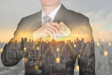 double exposure of Businessman put Euro money in his suit pocket and 4G 5G node networking cellsite and cityscape at sunset as business, investment, financial flexibility and saving concept.