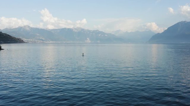 Overflying lonely paddler at dusk on Lake L&radic;&copy;man with the Alps in the background - Cully, Switzerland