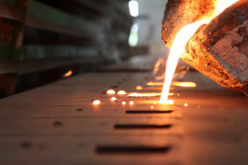 Casting iron by green sand process ; technology for Casting, in the metal industry, the process that molten metal is poured  into a mold , where it solidifies into shape , Industrial background - obrazy, fototapety, plakaty