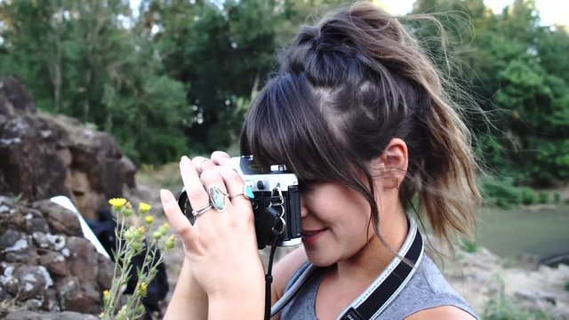 Handheld footage of a cute hipster girl talking and messing around with a camera