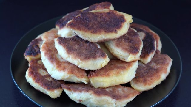 Potato cakes, ukrainian name potato zrazy, stuffed mushrooms or meat or cheese with herbs cream are fried in vegetable oil on black background, close up, rotates. Traditional Ukrainian cuisine