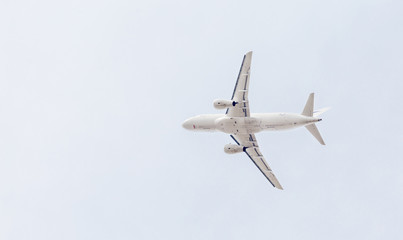 Snowy modern passenger jet aircraft flies in a blue sky. Journey and holidays concept. Aviation and transportation.