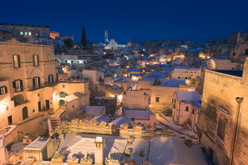 Naklejka premium Night shot of Matera, Basilicata, Italy: picturesque ancient streets in the old town called Sassi di Matera in snow, winter