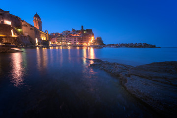 Naklejka premium Panorama of night fishing village Vernazza with Santa Margherita di Antiochia Church and lookout tower of Doria Castle, Five lands, Cinque Terre National Park, Liguria, Italy.
