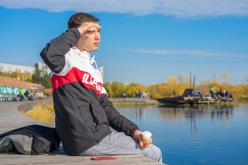 young guy covers his eyes from the sun