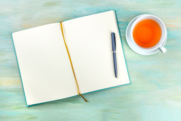An overhead photo of an open journal notebook with a pen and a cup of tea, shot from above, a diary...
