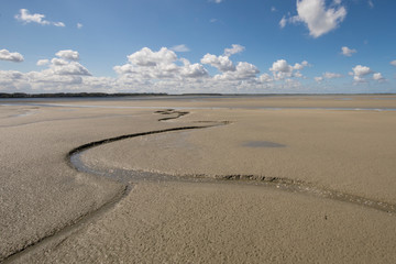 Litlle river flowing on the beach into sea, Somme Bay, Picardy, France.