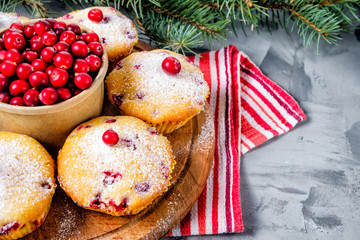 Cranberry cupcakes sprinkled with powdered sugar on a wooden tray