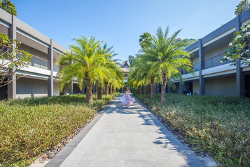 Woman dancing on the palm trees alley