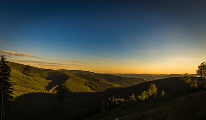 Yellow sunset and dark blue sky on path from Serak to Ramzova, scenic view on valleys in Jeseniky, Czech Republic