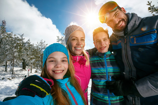 .family smiling and making selfie on winter ski vacation.