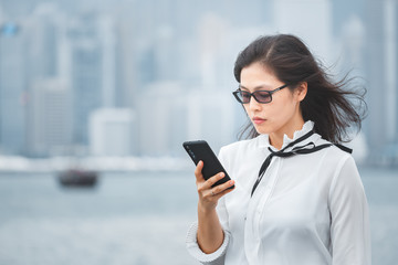 Fototapeta premium Successful business woman using smartphone in city